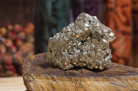 Foto de Pyrite Specimen on Raw Tigers Eye Rock With Dried Herbs in Background Shallow DOF - Imagen libre de derechos