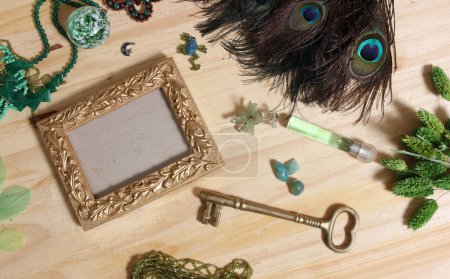 Foto de Joyería verde y plumas de pavo real con marco de oro en madera - Imagen libre de derechos