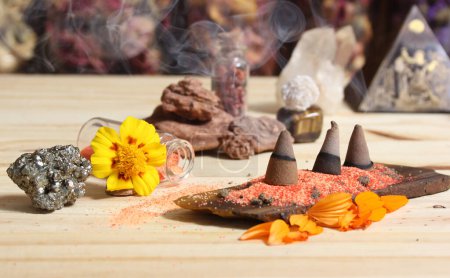 Foto de Conos de incienso en losa de piedra con cristales de chakra y flores - Imagen libre de derechos