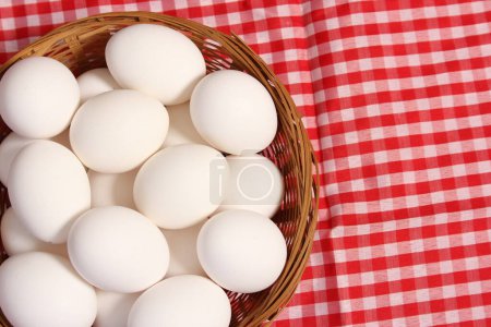 Photo for Basket of Farm Fresh Eggs on Red and White Checkered Table Cloth - Royalty Free Image