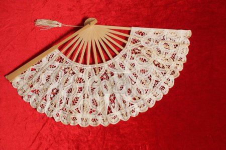 Vintage Cream Colored Lace Fan on Red Velvet Background
