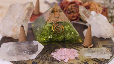 Kristallpyramide mit Kristallen und getrockneten Blumen auf antiken Sonnenuhren