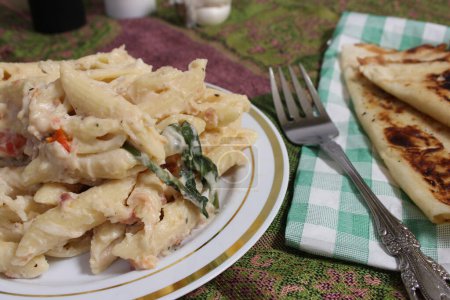 Foto de Placa de pasta Carbonara con pan plano italiano en mesa de cocina rústica - Imagen libre de derechos