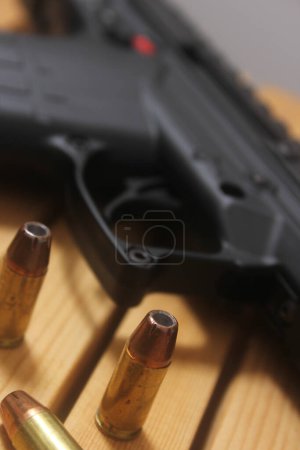Téléchargez les photos : Pistolet semi-automatique sur table en bois avec munitions - en image libre de droit