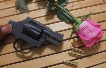 Pistolet vintage avec balles et rose. Revolver et munitions