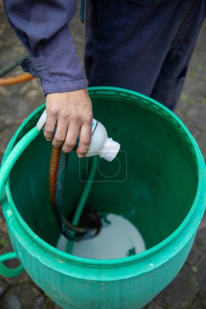 Photo for Pest exterminator employees are using pesticide sprayer at client's home and searching for as many nests as possible. An employee from pest control company is spraying chemicals to kill the insects. - Royalty Free Image