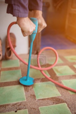 Photo for Exterminate termite control company employee is using a termite sprayer at customer's house and searching for termite nests to eliminate. exterminate control worker spraying chemical insect repellant - Royalty Free Image