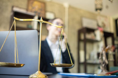 Brass court scales are used to decorate a table in a legal advisor office for aesthetic reasons ,Because the brass court scales are a symbol of justice. legal advisor concept.