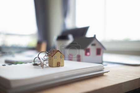 Immobilienverkaufsunterlagen und Musterhäuser werden auf Tischen in Immobilienverkaufsbüros platziert, um potenzielle Käufer darauf vorzubereiten, Immobilienkaufverträge mit Händlern zu unterzeichnen..