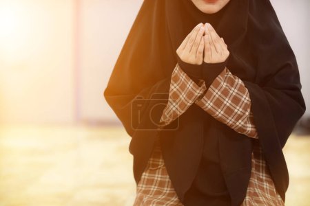 Foto de Las mujeres musulmanas en hiyab están orando para mostrar respeto y gracias a Allah de acuerdo con la creencia musulmana y las mujeres musulmanas en hiyab están orando a Allah de acuerdo con la creencia tradicional de Quran - Imagen libre de derechos