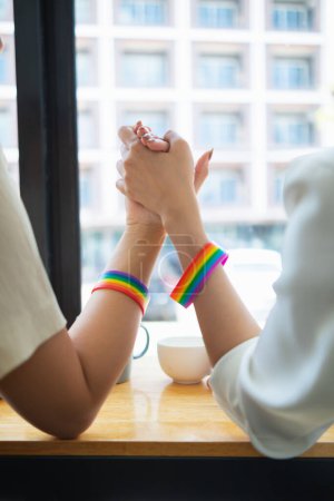 Photo for Lgbt Q couple wore rainbow wristbands symbolizing lgbt Q group and held hands to show love, friendship and kindness. And lgbt Q couple also promised to love each other forever. Copy space for text - Royalty Free Image