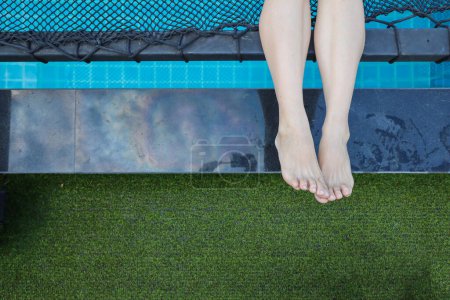 Photo for Woman in white see through pajama sits by pool alone lonely and depressed from her depression and having to take medication to reduce stress when alone. woman who is depressed because of being alone - Royalty Free Image