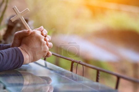 Photo for The hand of a young man praying to God for the power of God to fulfill the request of the Christian faith. The young man prayed to God for blessings based on his faith and power of faith in Him. - Royalty Free Image