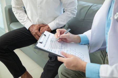 Téléchargez les photos : Young man meets with doctor for checkup His sexual performance was impaired and doctors examined his symptoms and discovered that he had suspected tumor growing inside his penis Prostate cancer - en image libre de droit