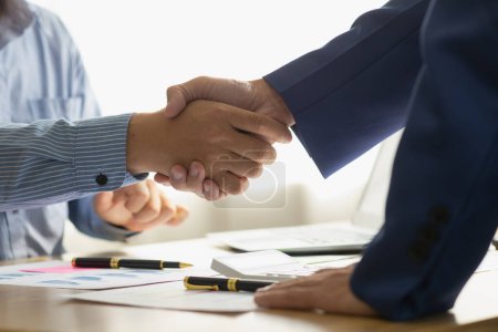 Businessmen and investors shake hands as symbol of joint venture after discussing, consulting and making contract to invest in business together. business people shaking hands as symbol of cooperation