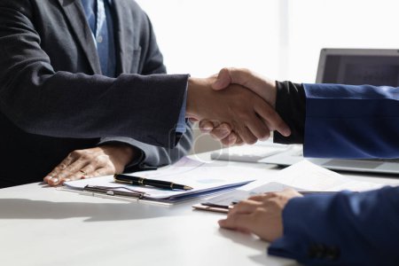 Geschäftsleute und Investoren schütteln sich die Hände als Symbol des Joint Ventures, nachdem sie gemeinsam diskutiert, beraten und Verträge abgeschlossen haben, um in Unternehmen zu investieren. Geschäftsleute schütteln Hände als Symbol der Zusammenarbeit