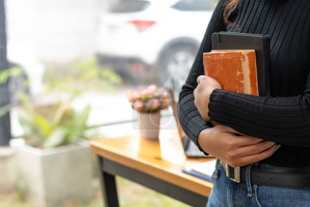 The young woman held a Bible in her hand and tried to learn and understand God teachings from the Bible she held. Concepts of belief and the power of faith in God and teachings from the Bible.