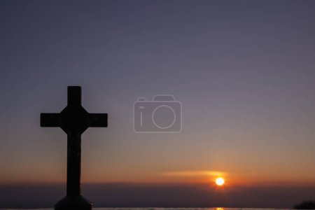 Die Silhouette eines Kreuzes auf dem Hintergrund eines Sonnenuntergangs in der Dämmerung ist ein Symbol für Gott, und das Kreuz wird auch für seine Göttlichkeit gehalten. Das Kreuz ist ein Symbol der Güte Gottes für alle Menschen.