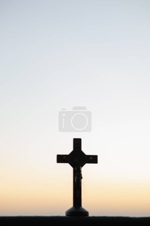The silhouette of a cross on the background of a twilight sunset is a symbol of God and the cross is also believed to be of His divinity. The cross is a symbol of God loving kindness for all people.