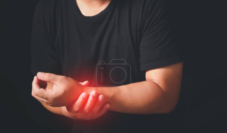 Síndrome del túnel carpiano, artritis, concepto de enfermedad neurológica, primer plano de los brazos masculinos sosteniendo su muñeca dolorosa causada por el trabajo prolongado en la computadora, computadora portátil, entumecimiento de la mano.