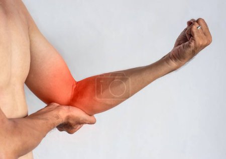 Photo for Pain in the elbow joint of Southeast Asian young man. Concept of elbow pain, injury, rheumatism or osteoarthritis. - Royalty Free Image