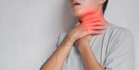 Tightness at the neck of Asian, Myanmar man. Concept of sore throat, pharyngitis, laryngitis, esophagitis, thyroiditis, dysphagia, choking or gasping.