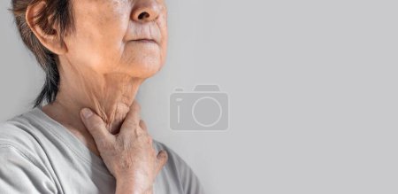 Photo for Pain at the neck of Asian, Myanmar woman. Concept of sore throat, pharyngitis, laryngitis, esophagitis, thyroiditis, or dysphagia. - Royalty Free Image