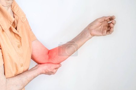 Photo for Pain in the arm of Southeast Asian old woman. Concept of elbow and forearm pain, injury or muscle problem. - Royalty Free Image