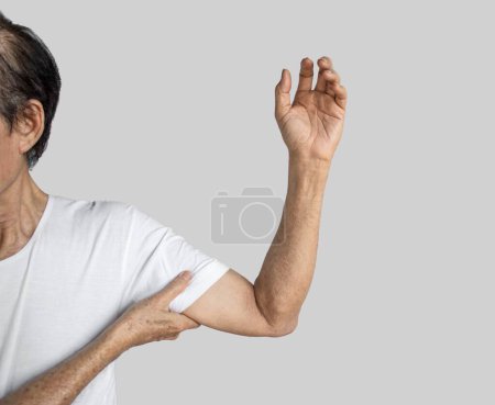 Téléchargez les photos : Stiffness in the shoulder joint of Southeast Asian elder man. Concept of frozen shoulder or arm muscle power problems. - en image libre de droit
