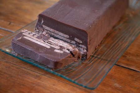 Photo for "Cold Dog" cake, or "Kalter hund", a dessert consists of butter biscuits layered in cocoa - coconut fat cream and is made by placing the biscuit layers one after the other in a loaf pan - Royalty Free Image