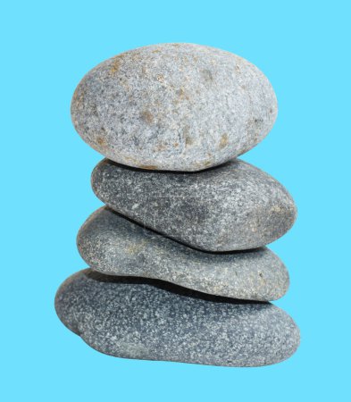 Photo for Balancing stone or rock isolated, natural pebble with clipping path, no shadow in blue background - Royalty Free Image