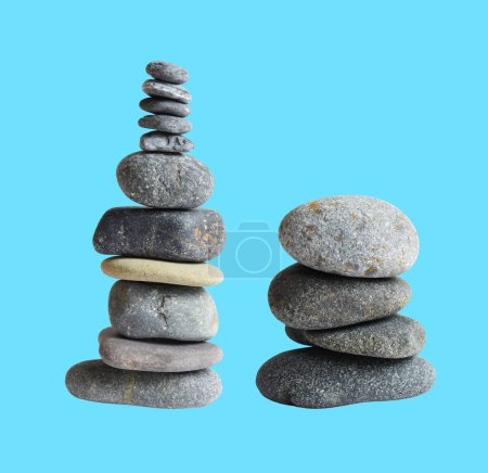 Photo for Balancing stone or rock isolated, natural pebble with clipping path, no shadow in blue background - Royalty Free Image