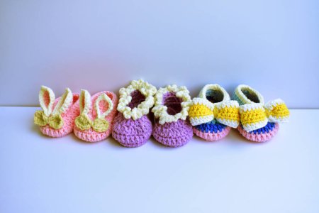 Häkeln neugeborenen Mädchen Schuhe oder Paar handgemachte Booties für Kinder isoliert in weißem Hintergrund, Schwangerschaft Mutterschaft Konzept, erste Geburtstagsfeier Banner
