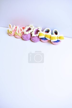 Photo for Crochet newborn baby girl shoes or pair of handmade booties for kids isolated in white background, pregnancy motherhood concept, first birthday party banner - Royalty Free Image
