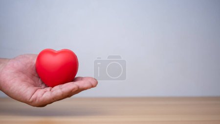 Téléchargez les photos : Bon concept de santé et d'assurance, concept d'assurance maladie. Main humaine tenant coeur rouge. - en image libre de droit