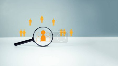 Customer group icons in a magnifying glass placed on a white background represent the selection of business goals, target customers, Marketing plans and strategies, customer-centric strategies.