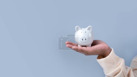 Ein Junge hält ein Sparschwein. Finanzverantwortung lernen und Ersparnisse projizieren. Sparkonzept. Investitionskonzept.