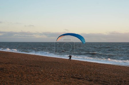 Photo for Paraglider walking on the beach, Dorset - Royalty Free Image