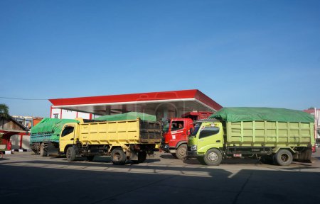 Foto de Sangatta, East Kalimantan / Indonesia-18 de abril de 2020: SPBU (Stasiun Pengisian Bahan Bakar Umum) o gasolinera. Una cola de camiones de transporte para repostar combustible diesel - Imagen libre de derechos