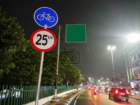 Foto de Señal de carril bici y señal de dirección en blanco verde, en la noche - Imagen libre de derechos