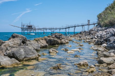 Photo for San Vito Chietino - 07-08-2022: The beautiful beach of Calata Turchina with crystal clear and blue sea and the trabocco in background - Royalty Free Image