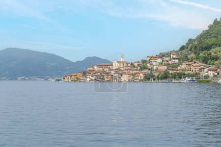 Téléchargez les photos : Monte Isola, Italie - 05-06-2022 : Paysage du bord du lac de Peshiera Maraglio à Monte Isola avec de belles maisons colorées reflétant dans l'eau - en image libre de droit