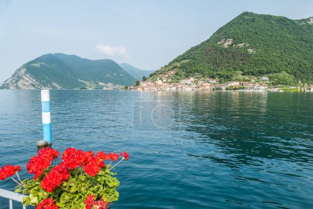 Téléchargez les photos : Monte Isola, Italie - 05-06-2022 : Paysage du bord du lac de Peshiera Maraglio à Monte Isola avec de belles maisons colorées reflétant dans l'eau - en image libre de droit
