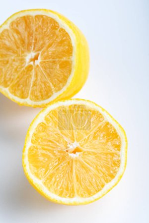 Photo for Fresh and juicy lemon cut in half. Lemon slices isolated on white background.Top view. Close-up. - Royalty Free Image