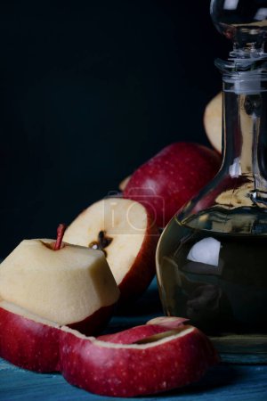 Foto de Manzanas frescas y vinagre de manzana en bootle sobre fondo de madera azul - Imagen libre de derechos