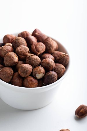 Hazelnuts in a bowl on a white background. Healthy food.