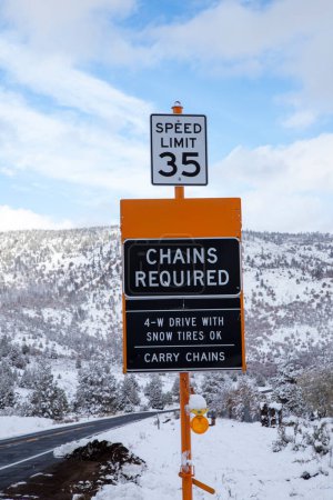 Téléchargez les photos : Une pancarte adjacente à la State Highway 139 dans le comté de Lassen, en Californie, aux États-Unis, avertit les automobilistes que des chaînes de neige sont nécessaires pendant une tempête. - en image libre de droit