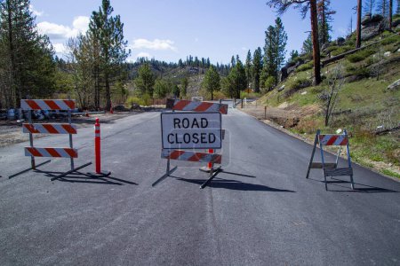 Barricades et signalisation marquent la fermeture d'une route dans la forêt nationale de Plumas en raison de réparations post-incendie Dixie en cours.