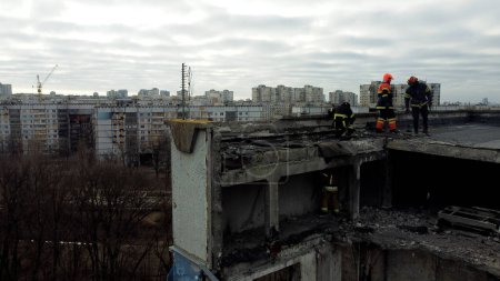 Foto de Kharkiv, Ukraine - January, 25, 2023: Rescuers walk on the roof of a multi-storey apartment building destroyed by a Russian missile strike in a Ukrainian city. Rescue operation during the Russian - Imagen libre de derechos