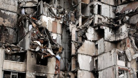 Foto de Destruido por un golpe de artillería rusa, un edificio residencial de varios pisos en una ciudad ucraniana. Ruinas de un edificio de 16 pisos en la ciudad ucraniana de Jarkov. El ejército ruso destruye el - Imagen libre de derechos